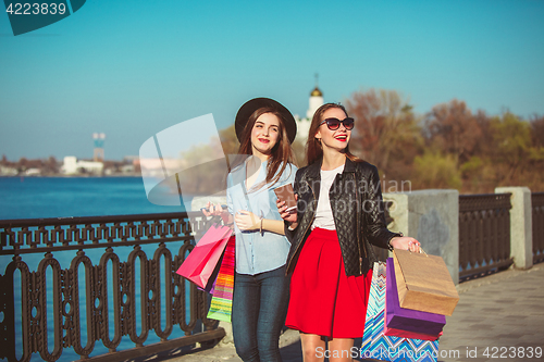 Image of Two girls walking with shopping on city streets