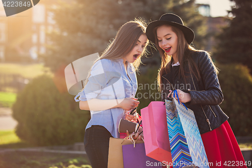 Image of Two girls walking with shopping on city streets