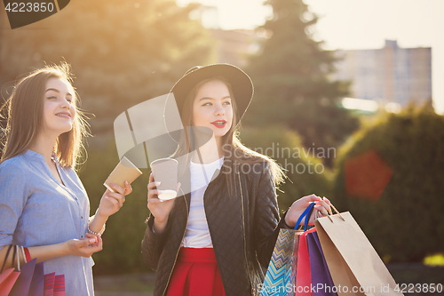 Image of Two girls walking with shopping on city streets