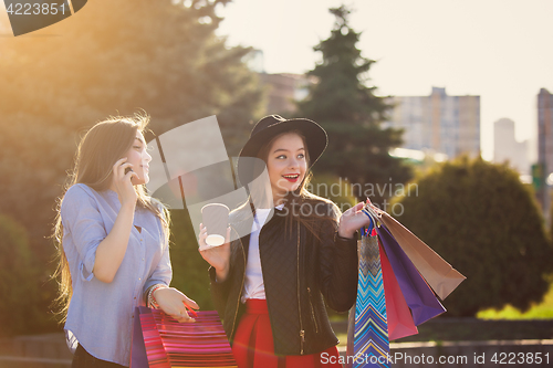 Image of Two girls walking with shopping on city streets