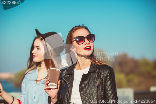 Image of Two girls walking with shopping on city streets