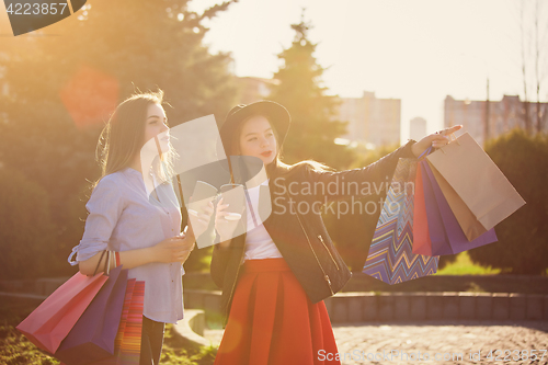 Image of Two girls walking with shopping on city streets