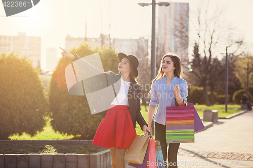 Image of Two girls walking with shopping on city streets