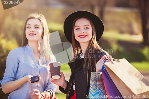 Image of Two girls walking with shopping on city streets