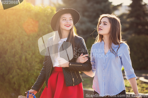 Image of Two girls walking with shopping on city streets