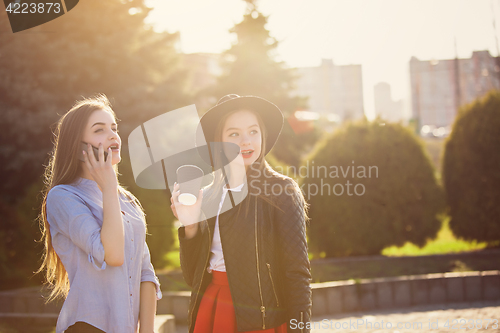 Image of Two girls walking with shopping on city streets