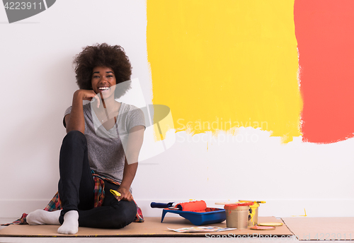 Image of back female painter sitting on floor