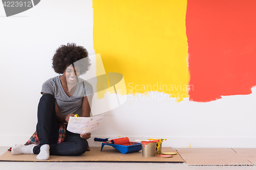 Image of back female painter sitting on floor