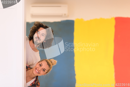 Image of portrait of a couple painting interior wall