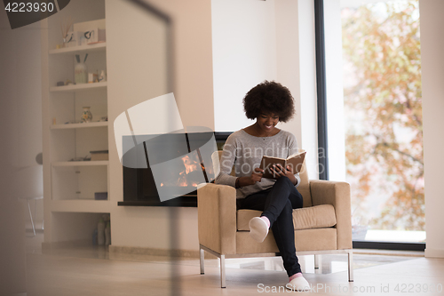 Image of black woman at home reading book
