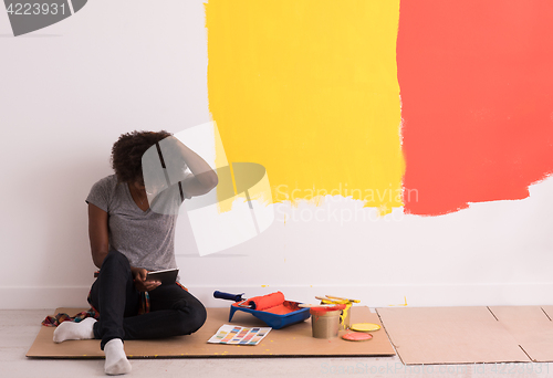 Image of back female painter sitting on floor