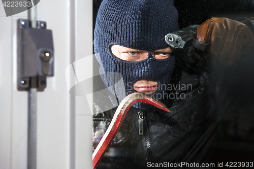 Image of Intruder with crow bar and hand gun