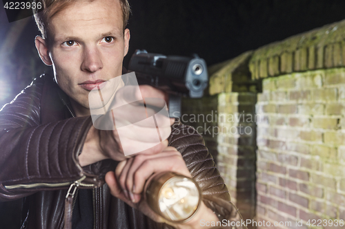 Image of Special Agent with service gun and torch in alley