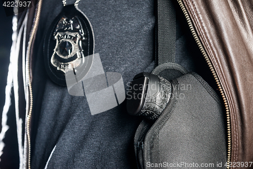 Image of Closeup midsection of police officer with badge and gun in holst