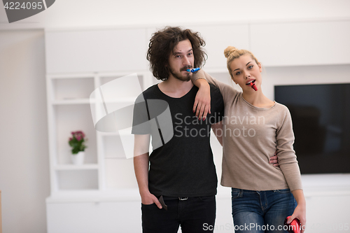 Image of couple in party hats blowing in whistle