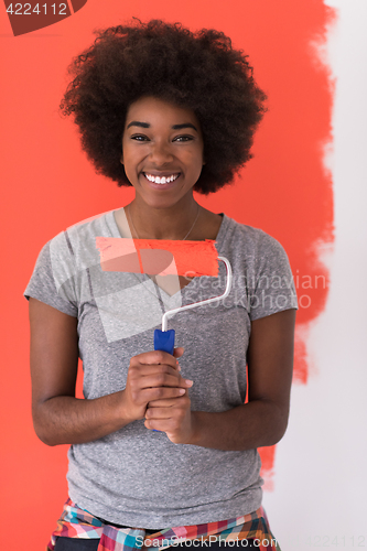 Image of black woman painting wall