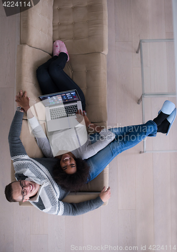 Image of happy multiethnic couple relaxes in the living room