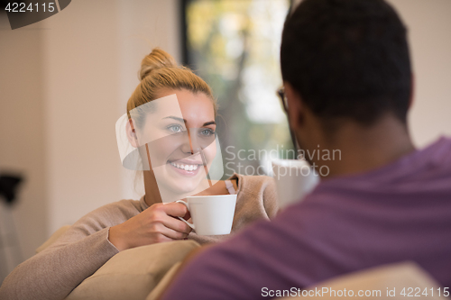 Image of Young multiethnic couple  in front of fireplace