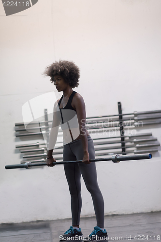 Image of black woman lifting empty bar