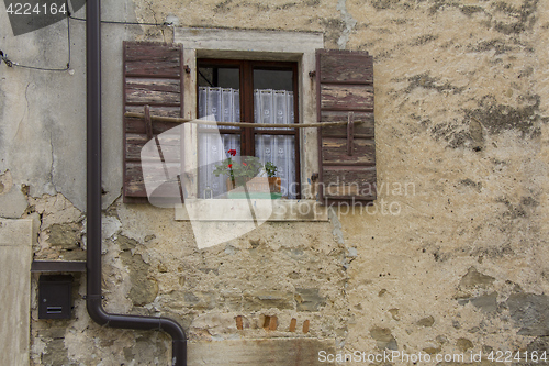 Image of Brown wooden window shutters on the old stone house