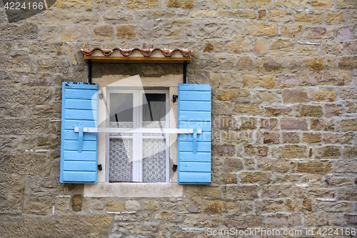 Image of Blue wooden window shutters on the old stone house