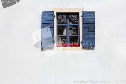 Image of Blue window shutters on the white facade