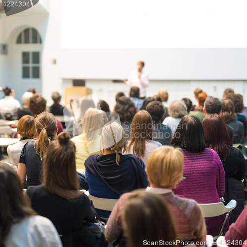 Image of Woman giving presentation in lecture hall at university.