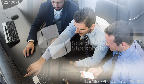 Image of Business team analyzing data on computer.