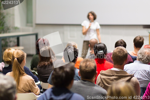 Image of Woman giving presentation in lecture hall at university.