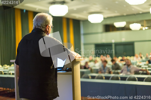 Image of Senior public speaker giving talk at scientific conference.