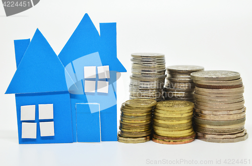 Image of House model and stacks of coins