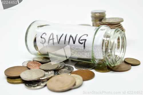 Image of Saving lable in a glass jar with coins spilling out