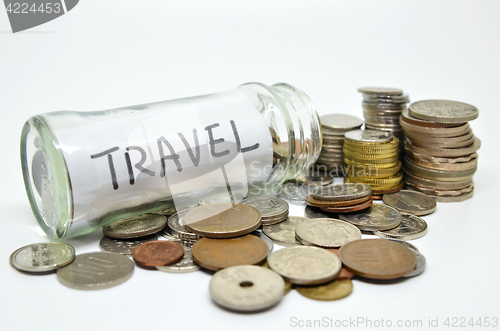 Image of Travel lable in a glass jar with coins spilling out