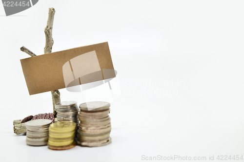 Image of Paper sign board with stack of coins