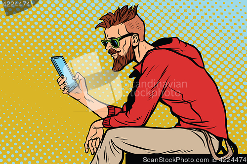 Image of The hipster looks at smartphone