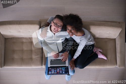 Image of happy multiethnic couple relaxes in the living room