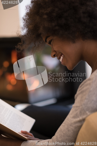 Image of black woman at home reading book