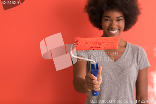 Image of black woman painting wall