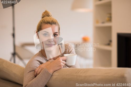 Image of woman with a mug near a fireplace