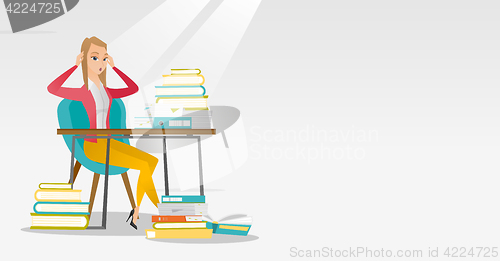 Image of Student sitting at the table with piles of books.