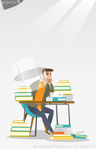 Image of Student sitting at the table with piles of books.