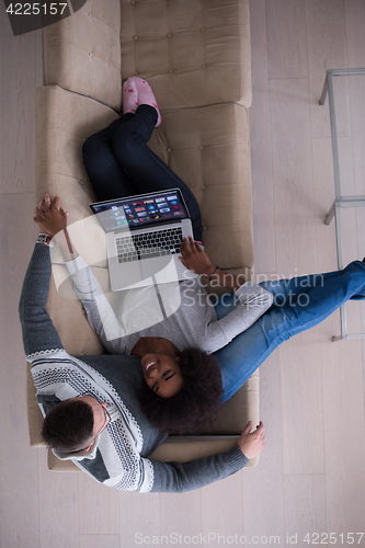 Image of happy multiethnic couple relaxes in the living room