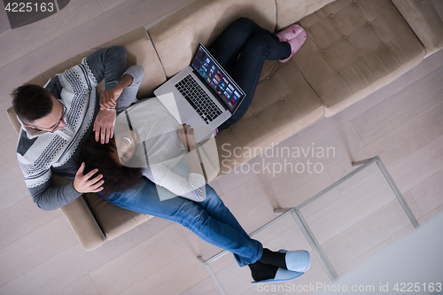 Image of happy multiethnic couple relaxes in the living room