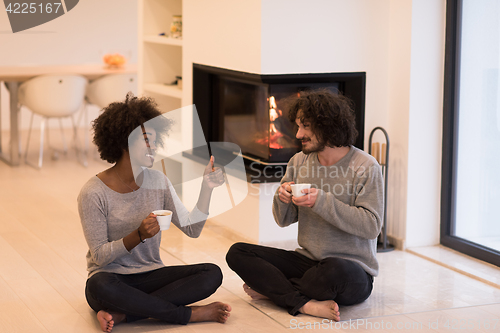 Image of multiethnic couple  in front of fireplace