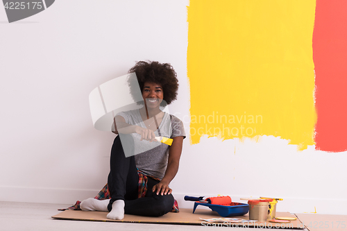 Image of back female painter sitting on floor