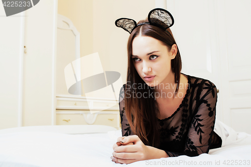 Image of young pretty brunette woman wearing sexy lace mouse ears, laying