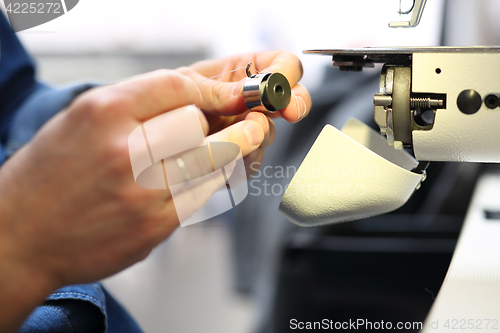 Image of Sewing. Sewing machine  Seamstress sewing on the sewing machine in the manufacturing plant 