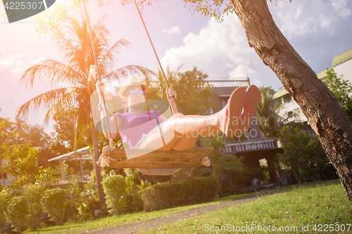 Image of Girl at palm trees swings