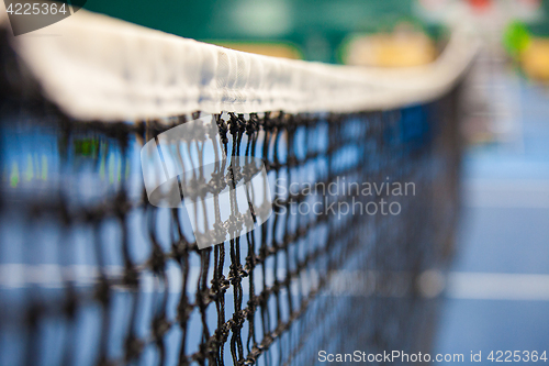 Image of Close up view of tennis court through the net