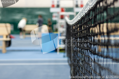 Image of Close up view of tennis court through the net